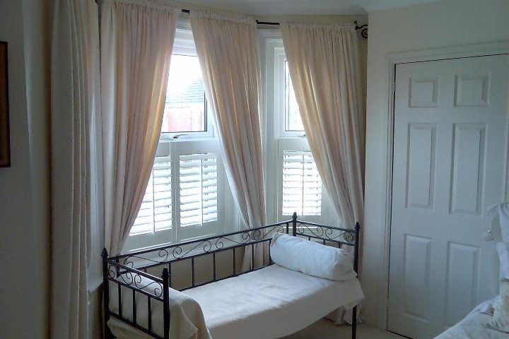 Half window shutters uk example - cafe style shutters in bedroom